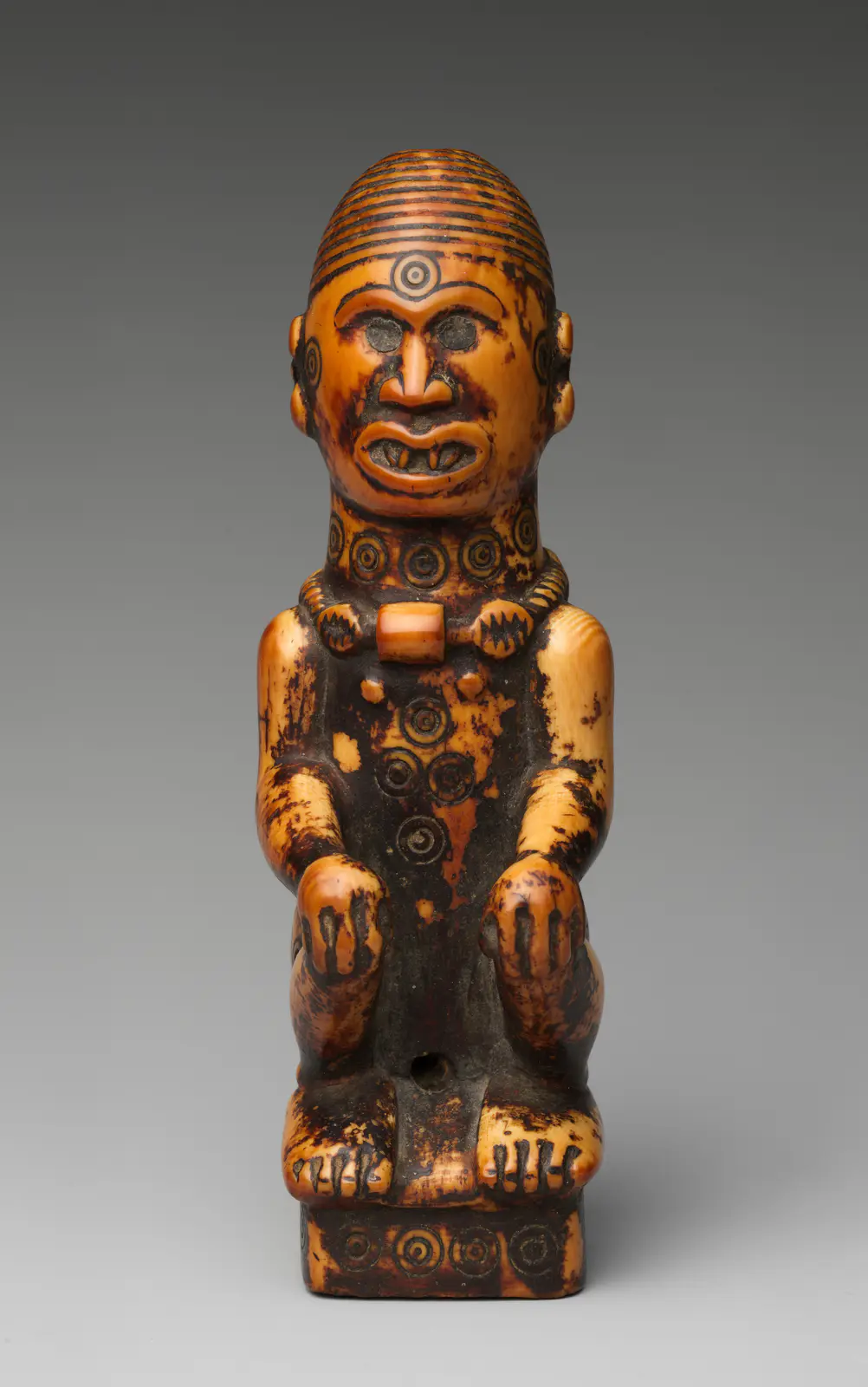 Staff finial with seated woman