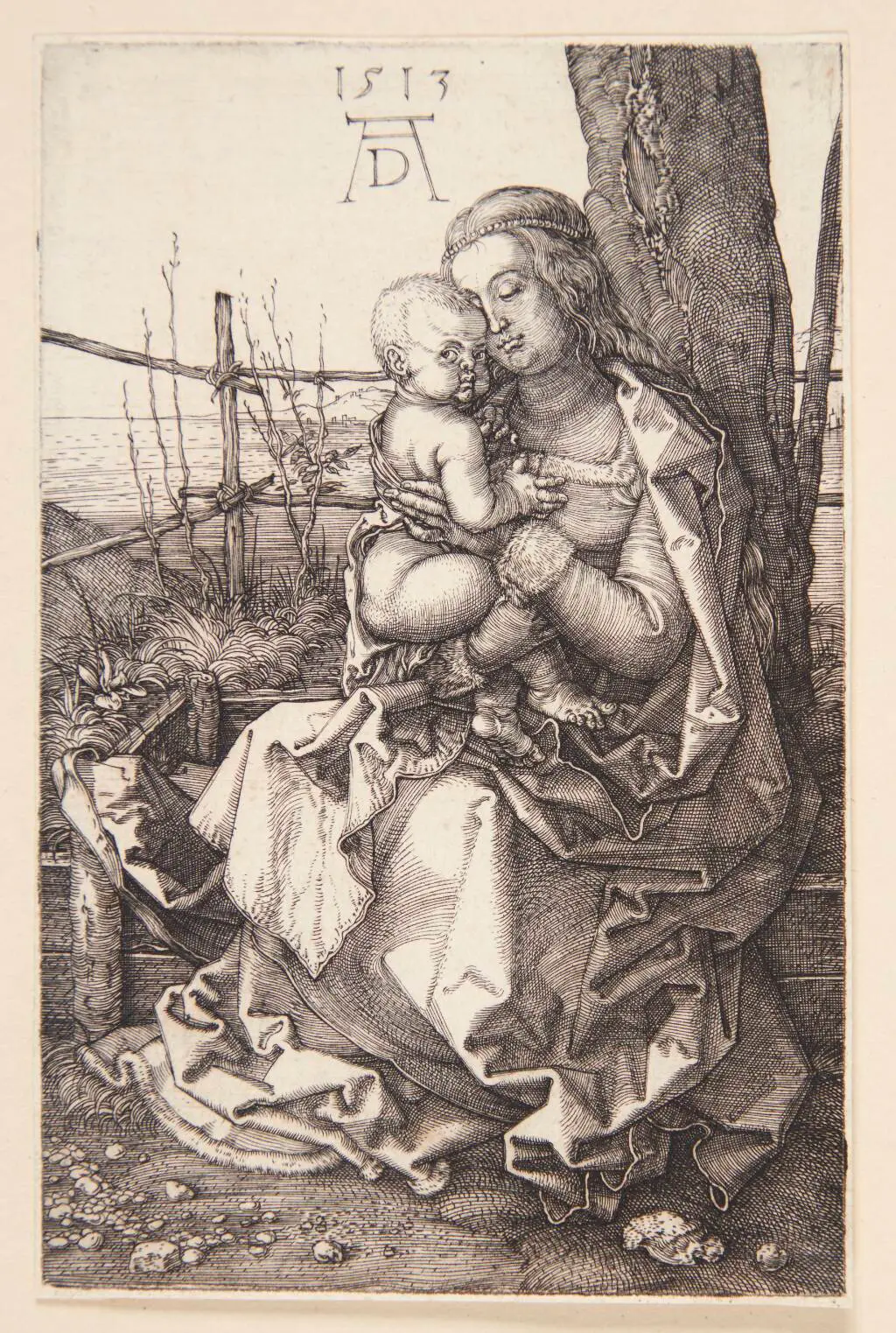 Madonna, siddende ved et træ